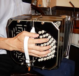 알프레드 아놀드 반도네온의 오른손 쪽(고음 쪽). 각 버튼에 표시된 숫자나 기호에도 주목. 엄지손가락은 공기 배출 레버에 닿아 있다. 손목 부분은 무늬가 있는 그릴(격자창과 같은 구멍을 낸 판)로 되어 있다.