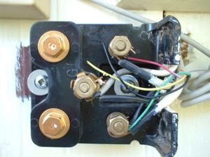 전화 네트워크 인터페이스 장치에 장착된 스파크 갭 과전압 보호기. 왼쪽에 있는 두 개의 황동 육각 헤드 물체는 팁 또는 링 라인의 과전압을 접지로 단락시키는 보호기이다.