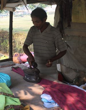숯 다리미를 사용하여 옷을 다림질하는 남자