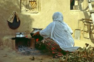실내에서 장작을 사용해 요리하는 사람
