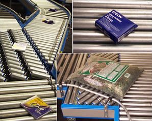 라인샤프트 롤러 컨베이어가 유통 센터에서 상자에 담긴 제품을 운반하고 있다.