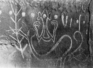 아나 오 케케(Ana o Keke) 동굴 내부 암각화. 깃털 모양 롱고롱고 문자 3(왼쪽), 합자 문자 211:42(중앙)와 비슷한 그림이 있다. 두 문자를 가로지르듯 컵 모양 둥근 기호 열이 있고, 끝에는 V자형 그림(문자 27)이 보인다.