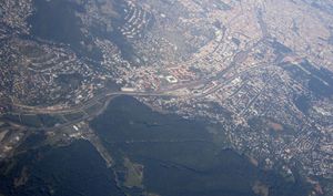 사진 상단에 오토 바그너 병원이 있는 펜칭의 항공 사진 (3열의 큰 건물), 그 아래 사각형 모양의 게르하르트 하나피 슈타디온, 그리고 그 사이에 바움가르텐과 상당한 규모의 바움가르트너 묘지.