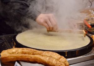 젠빙궈쯔 조리 과정 2단계: 달걀을 깨서 반죽 위에 펴 바른다.