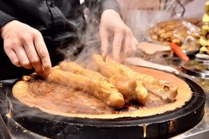 젠빙궈쯔 조리 과정 3단계: 뒤집어서 소스와 파 등을 바른다.