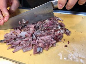 정어리를 칼로 다지고 있는 모습.
