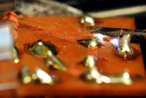 전자 회로 기판의 단자를 드라이버로 고의로 단락시킨 모습.