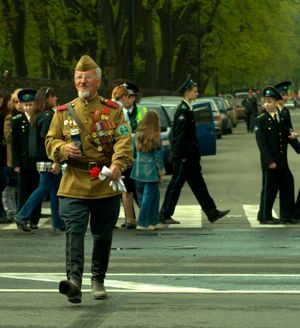 대조국 전쟁 참전 용사 복장을 한 남성이 짐나스트요르카와 필로트카를 모두 착용하고 있다.