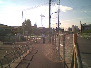 2004년 9월 호야역 북쪽 출구의 도시계획도로. 원경에 북쪽 출구가 보인다. 2005년 1월 현재 역전 로터리로부터 약 200m 구간은 도로 폭이 넓게 정비되어 있지만, 그 이북은 나무 말뚝에 철사를 친 채 방치된 빈 땅으로 남아 있다.